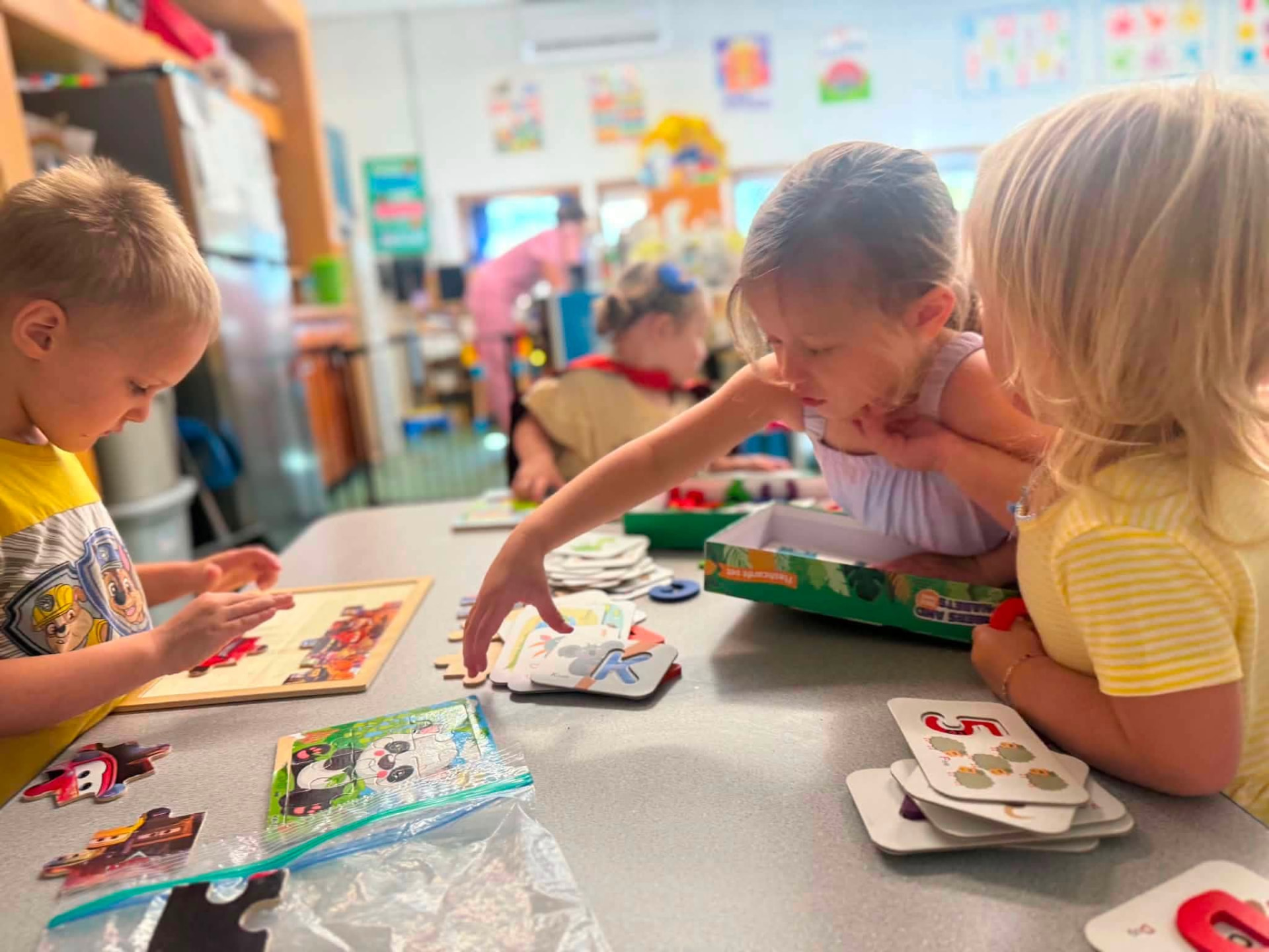Children working on puzzles and letter cards together at St. Mary